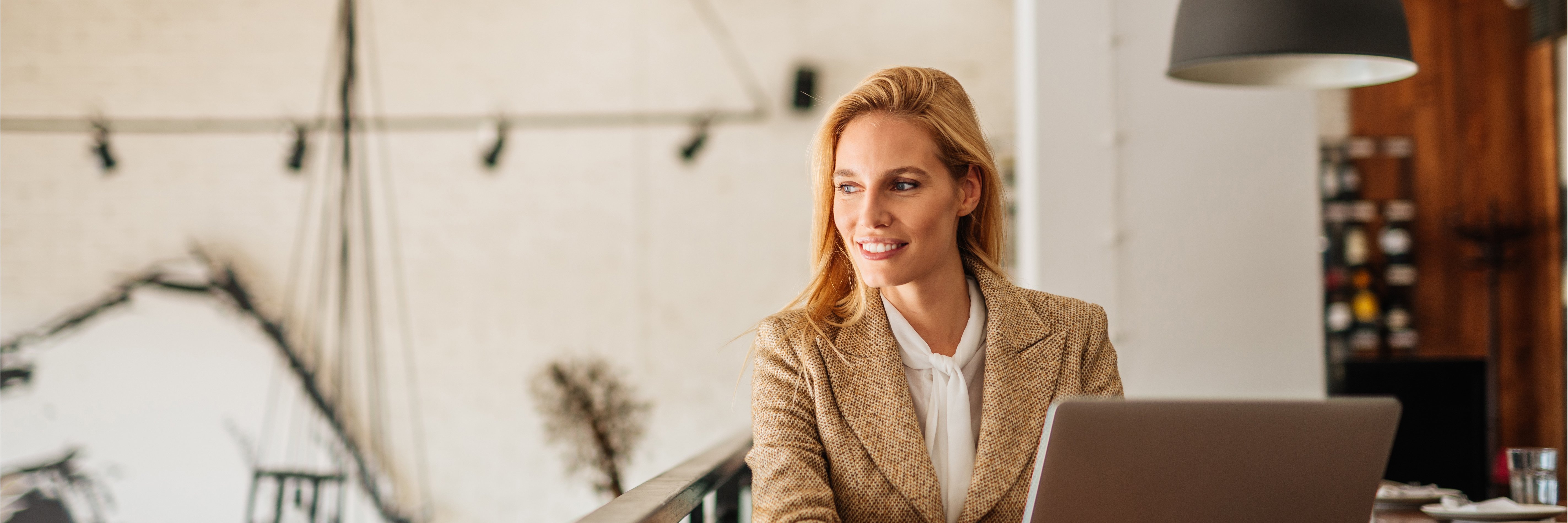 Woman smiling looking to her left with a laptop in front of her Woman smiling looking to her left with a laptop in front of her
