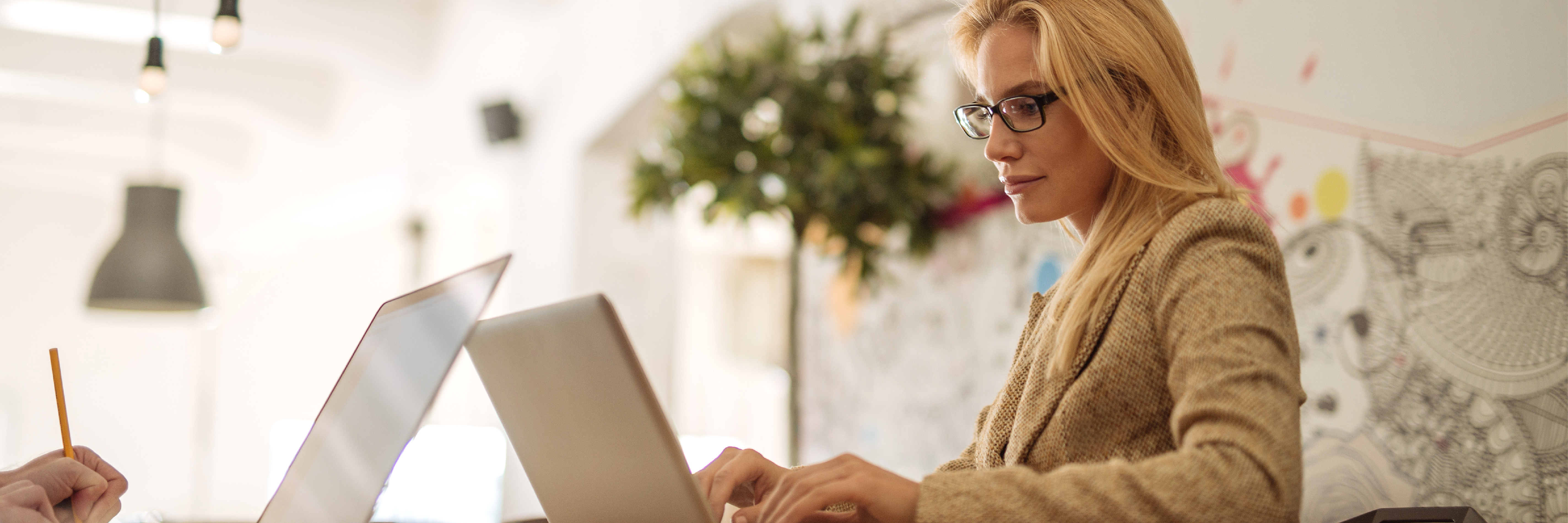 Woman wearing spectacles working on laptop