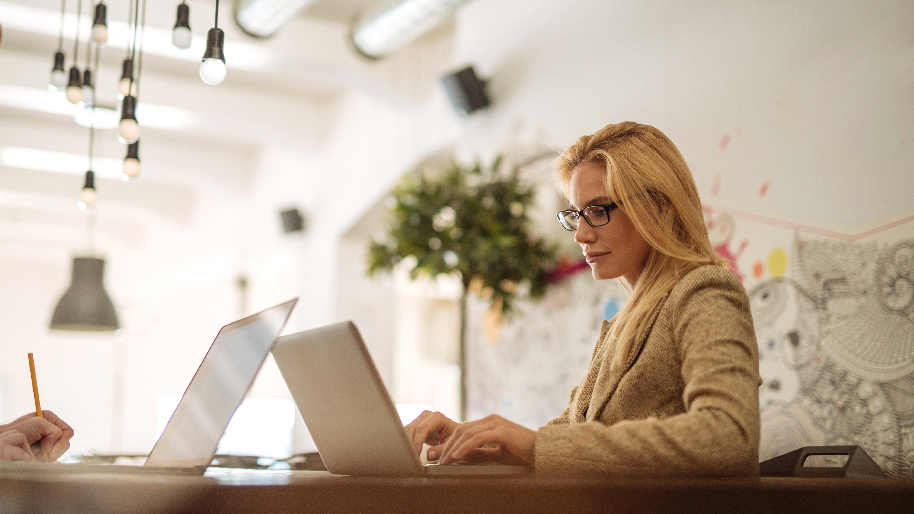 Woman wearing spectacles working on laptop
